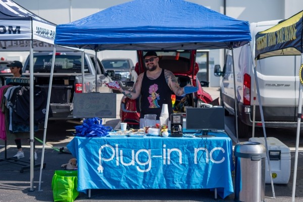 Man standing under a tent at a booth at the Glizzies n' Gainz event.